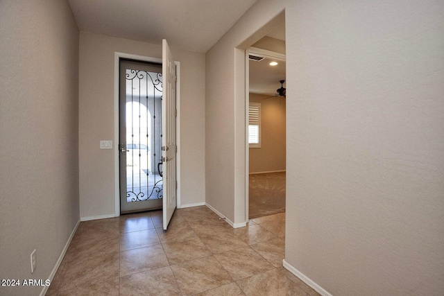 entryway featuring light tile patterned floors and ceiling fan