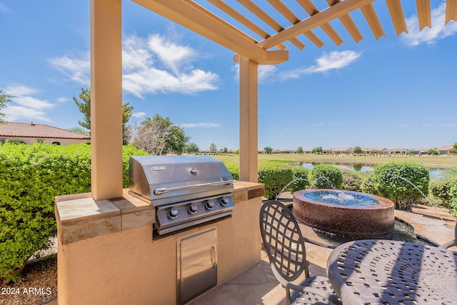 view of terrace with grilling area, an outdoor kitchen, and a pergola