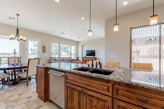 kitchen with dark stone countertops, pendant lighting, sink, light tile flooring, and dishwasher