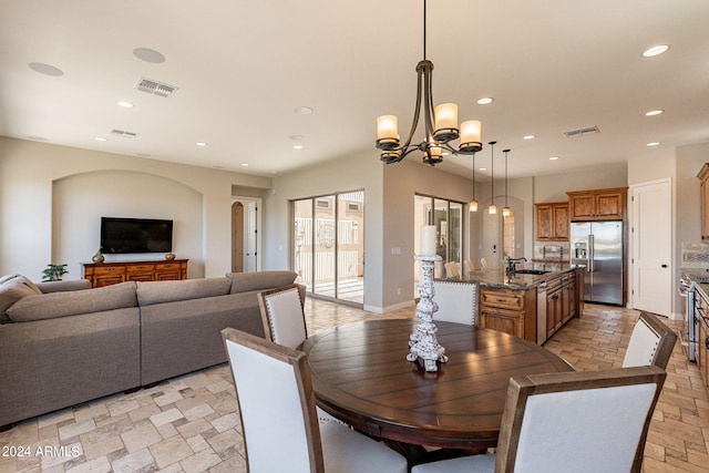 dining space featuring sink and an inviting chandelier