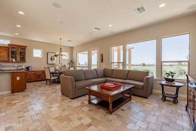 living room with a healthy amount of sunlight, an inviting chandelier, and light tile floors