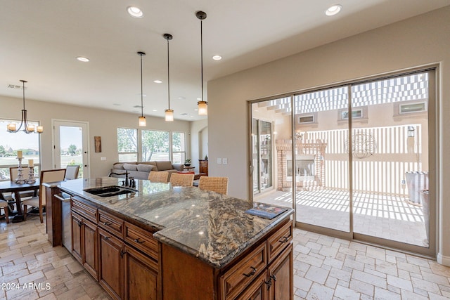 kitchen featuring a chandelier, sink, a kitchen island, and pendant lighting