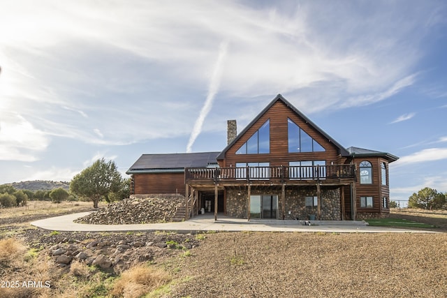 4177 W Finch Hollow Ave, Chino Valley, AZ 86323 - rear view of house featuring stone siding, a chimney, a patio, and a deck