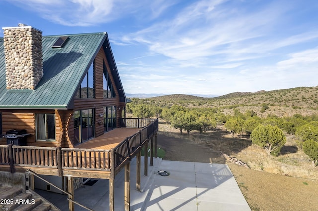 4177 W Finch Hollow Ave, Chino Valley, AZ 86323 - view of property exterior featuring log exterior, a deck with mountain view, a chimney, and metal roof