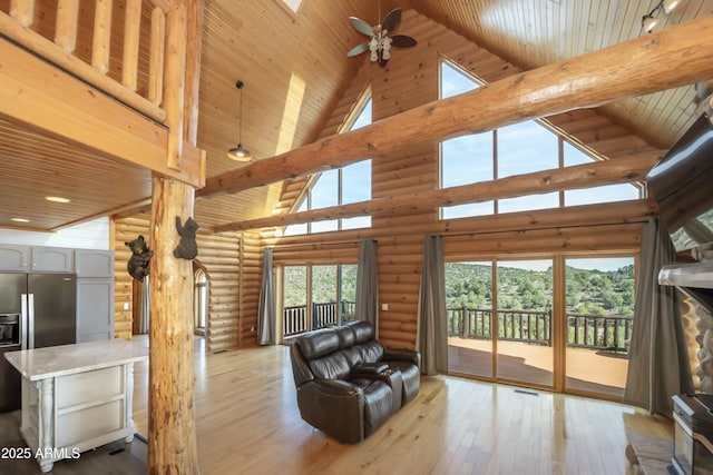 4177 W Finch Hollow Ave, Chino Valley, AZ 86323 - living area featuring rustic walls, light wood-style flooring, a ceiling fan, and high vaulted ceiling