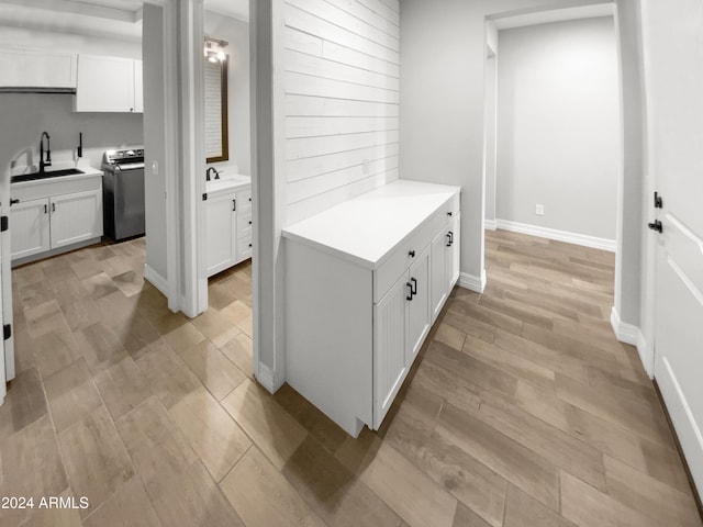 interior space featuring light hardwood / wood-style floors, washer / clothes dryer, and sink