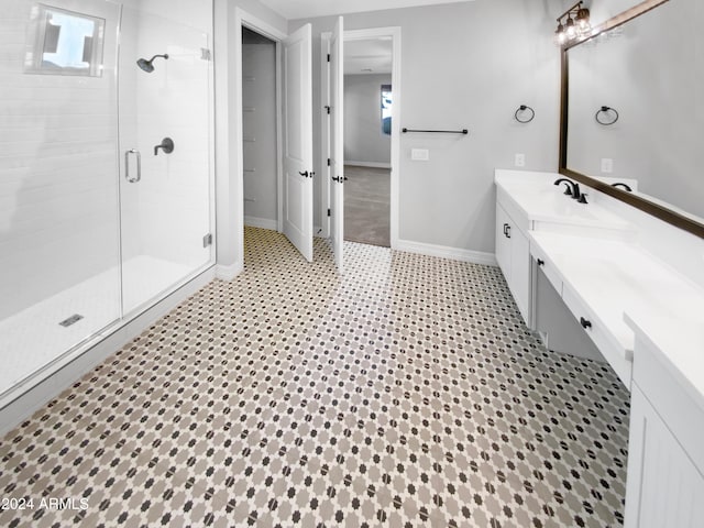 bathroom featuring a shower with door and vanity