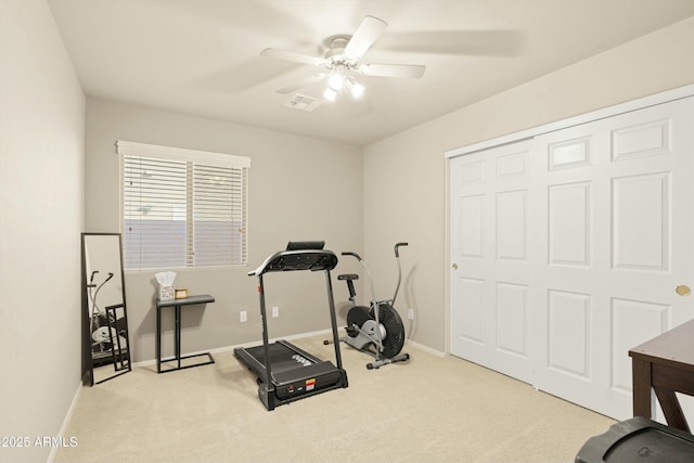 exercise room with ceiling fan and light colored carpet