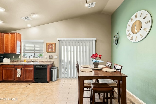 kitchen with sink, black dishwasher, light stone counters, lofted ceiling, and light tile patterned floors