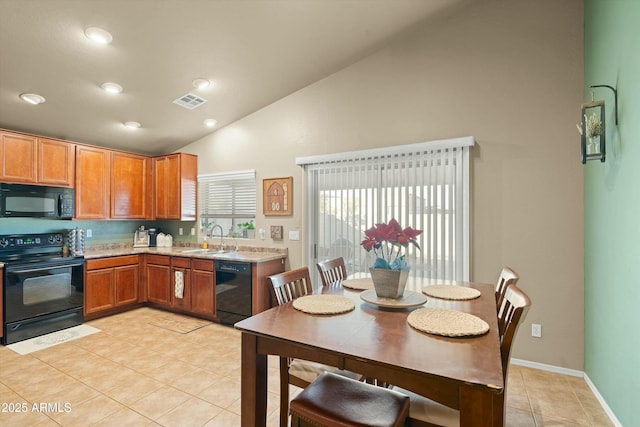 kitchen with light tile patterned floors, sink, vaulted ceiling, and black appliances