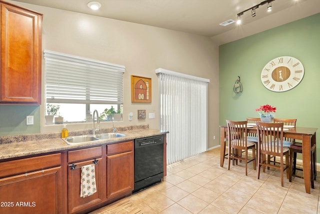 kitchen featuring rail lighting, sink, light tile patterned floors, and black dishwasher