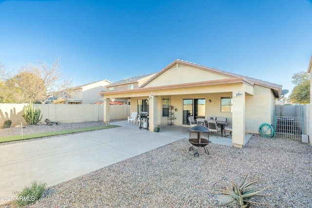 rear view of house with a patio and a fire pit