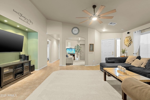 tiled living room with ceiling fan and vaulted ceiling