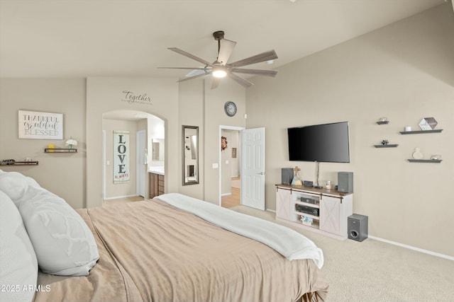 carpeted bedroom with ceiling fan, ensuite bathroom, and vaulted ceiling