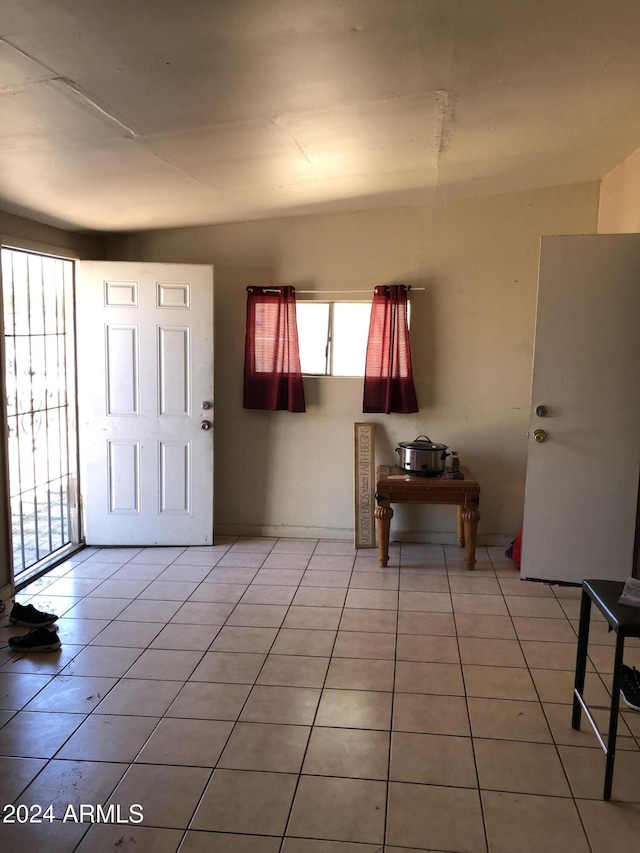 entryway featuring light tile patterned flooring and vaulted ceiling