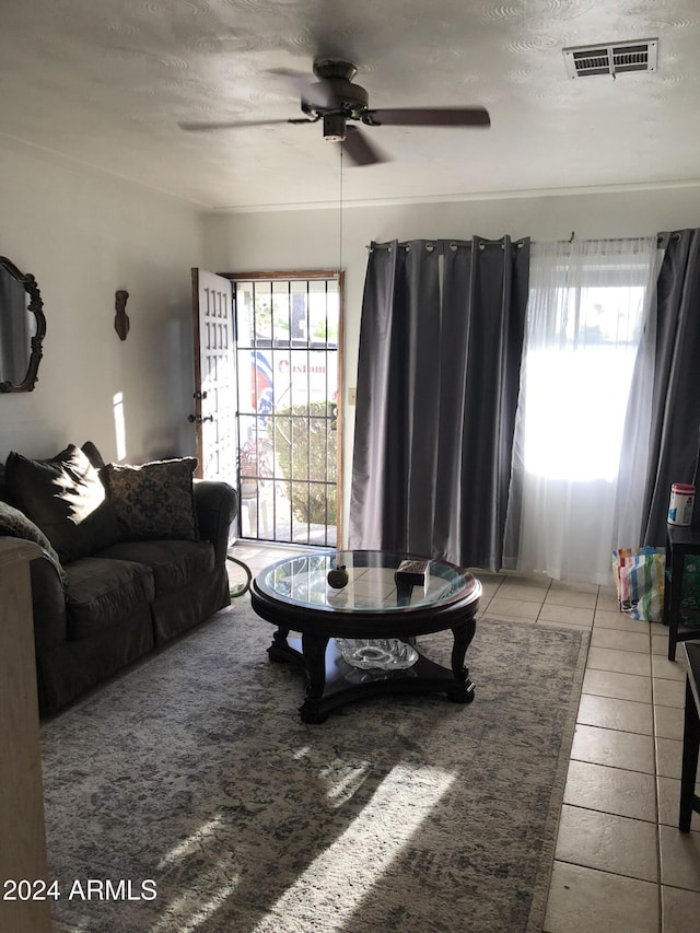 tiled living room with ceiling fan and a textured ceiling