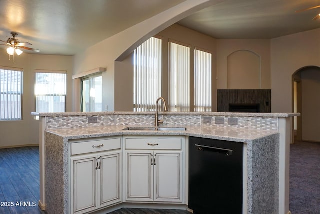 kitchen featuring light stone counters, a sink, white cabinets, black dishwasher, and open floor plan