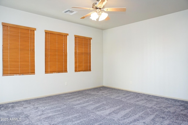 carpeted empty room with a ceiling fan, visible vents, and baseboards