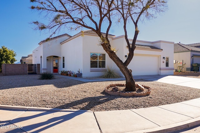 view of front facade featuring a garage, fence, concrete driveway, and stucco siding