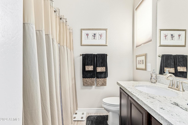 bathroom featuring toilet, walk in shower, and vanity