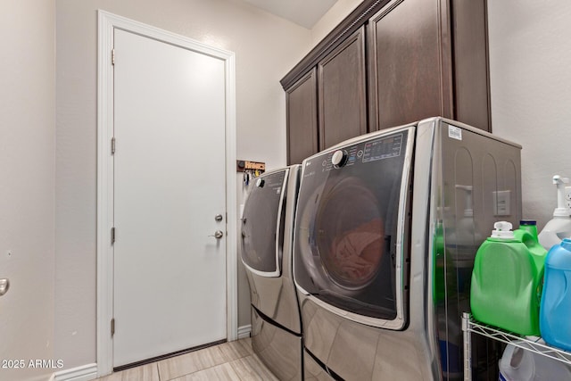 washroom with washer and dryer, cabinets, and light tile patterned floors