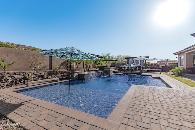 view of swimming pool with pool water feature, a patio area, and a jacuzzi