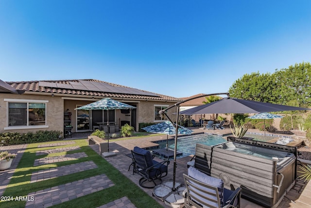 view of patio / terrace with a swimming pool with hot tub