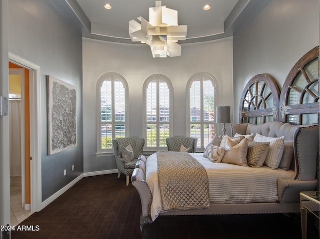 bedroom featuring a tray ceiling and a towering ceiling