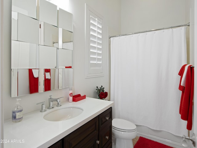 full bathroom featuring vanity, shower / tub combo, and toilet