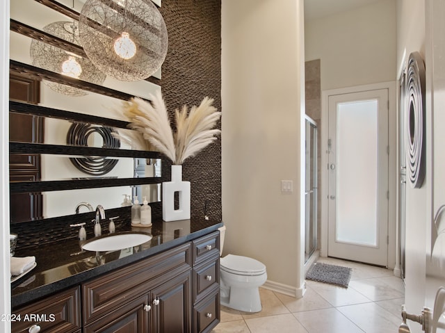 bathroom featuring walk in shower, vanity, toilet, and tile patterned flooring