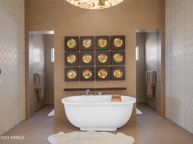 bathroom featuring tile walls, a washtub, and tile patterned flooring