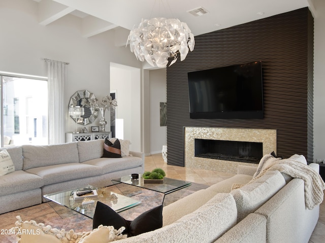 living room with beamed ceiling, a fireplace, a chandelier, and light tile patterned floors