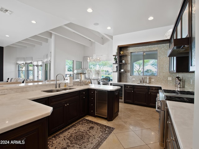 kitchen featuring light tile patterned flooring, stainless steel stove, tasteful backsplash, sink, and wine cooler