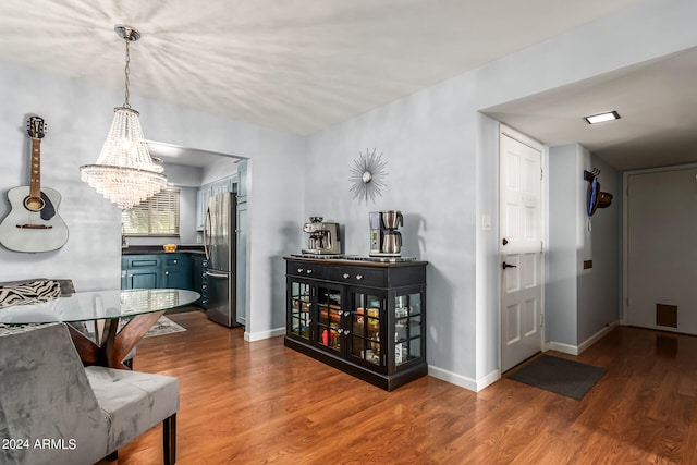 dining area with hardwood / wood-style floors and an inviting chandelier