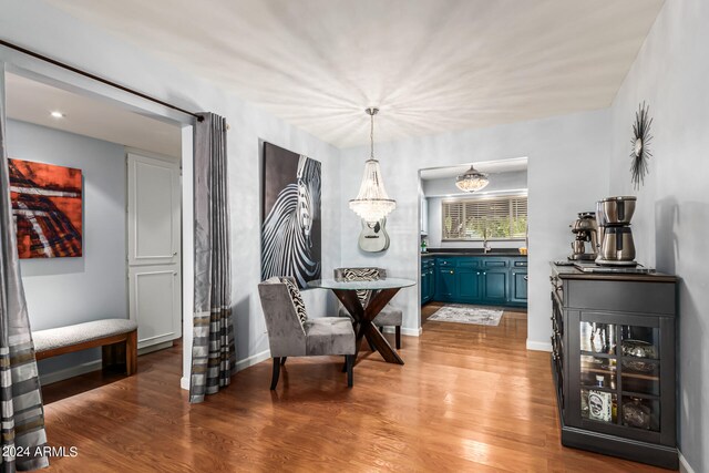 dining room with hardwood / wood-style flooring, sink, and a chandelier