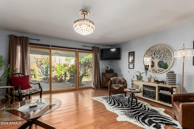 living room featuring hardwood / wood-style flooring, a chandelier, and a fireplace