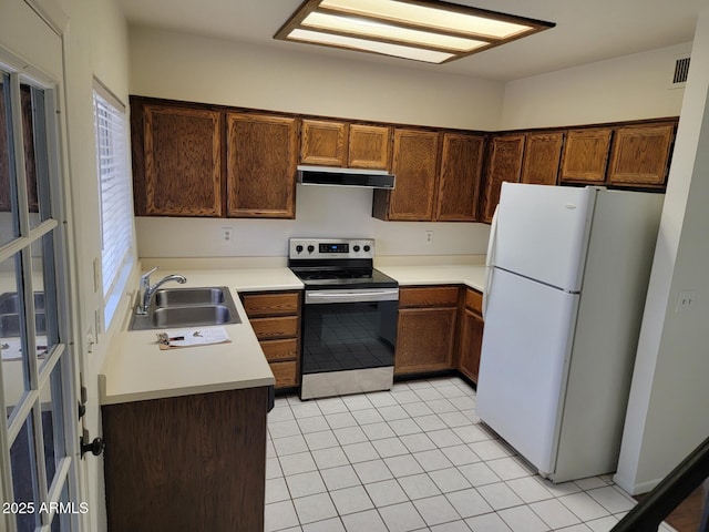 7801 N 44th Dr Unit 1036, Glendale, AZ 85301 - kitchen with electric range, freestanding refrigerator, extractor fan, light countertops, and light tile patterned flooring