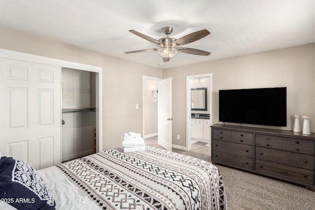 bedroom with baseboards, a ceiling fan, light colored carpet, ensuite bath, and a closet