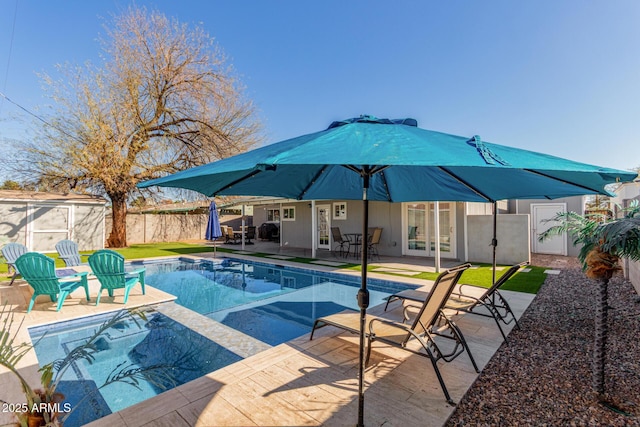 view of swimming pool featuring a fenced in pool, french doors, a patio area, and a fenced backyard