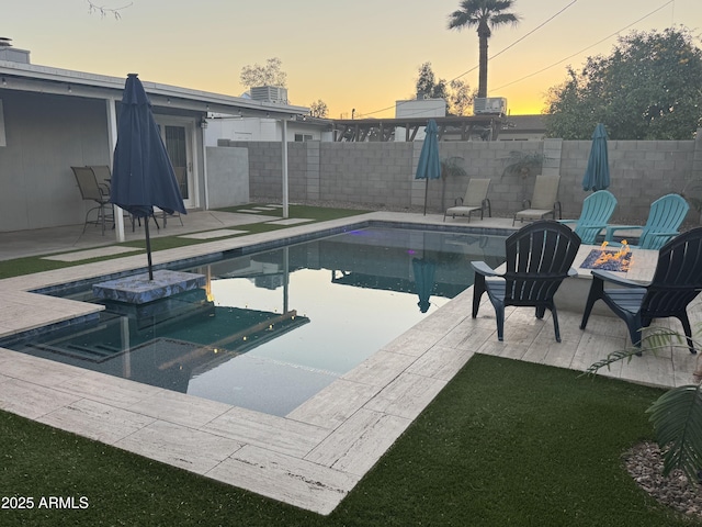 view of pool with a fenced in pool, a fenced backyard, a patio, and a fire pit