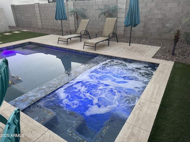 view of pool featuring a hot tub, fence, a fenced in pool, and a patio