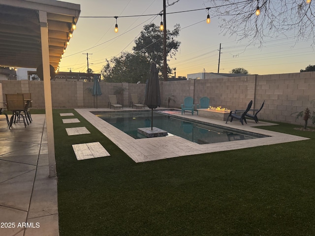 pool at dusk with an outdoor fire pit, a fenced in pool, a lawn, a fenced backyard, and a patio area