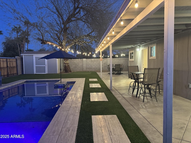 view of pool with a patio, a shed, an outdoor structure, and a fenced backyard