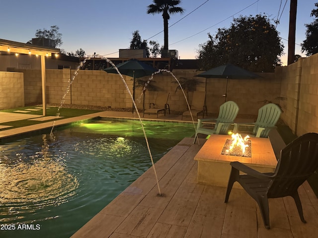 view of swimming pool with a fenced in pool, a fenced backyard, and a fire pit