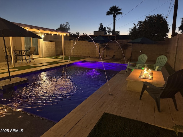 view of pool with a fenced backyard, a fire pit, and a fenced in pool