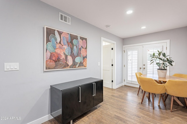 dining space featuring light wood-type flooring and french doors