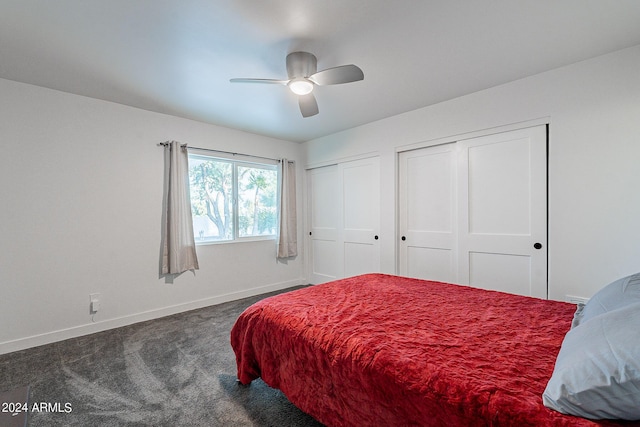 carpeted bedroom with ceiling fan and two closets