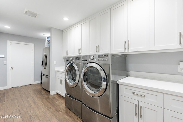 laundry room with cabinets, separate washer and dryer, and hardwood / wood-style floors