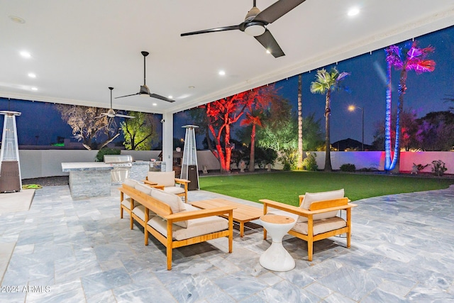 view of patio / terrace with ceiling fan, an outdoor kitchen, an outdoor living space, and a grill