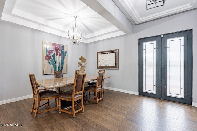 dining room with a chandelier, dark hardwood / wood-style floors, and a tray ceiling